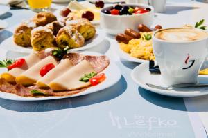a table with plates of food and a cup of coffee at Ponti Beach Hotel in Vasiliki