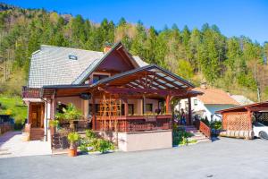 a house in the mountains with a car parked in front at Guesthouse Veranda in Mojstrana