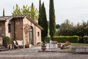 a stone house with a table and chairs in a garden at Montorio in Montepulciano