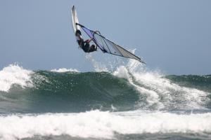 un hombre montando una ola en una tabla de surf en el océano en Centrebreak Beach Stay en Green Head