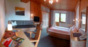 uma sala com um quarto com uma cama e um sofá em Alpenhof Wohlfühlpension em Obsteig