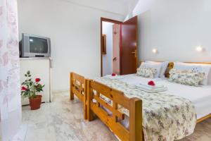a bedroom with a bed and a tv on a wall at Summer Rooms in Skala Kallirakhis