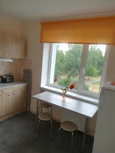 a kitchen with a table and two chairs and a window at Couple getaway to a freshly renovated apartment in Pärnu