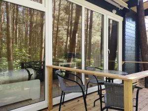 a screened in porch with a table and chairs at Ku kū in Šventoji