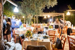 a group of people standing around a restaurant at night at Tenuta TerraRossa in Rossano