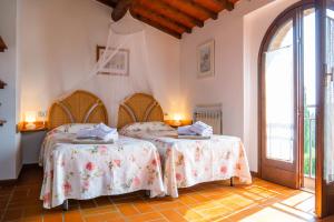 a bedroom with two beds and a large window at Pian della Casa in Montaione
