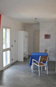 une chambre blanche avec une table et des chaises bleues dans l'établissement Vacanze in Puglia, à San Pietro in Bevagna