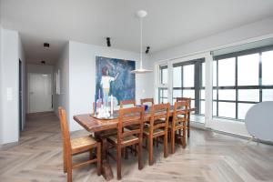 una sala da pranzo con tavolo e sedie in legno di Ocean View Luxury Apartment in Central Reykjavik a Reykjavik
