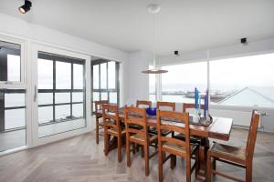 a dining room with a table and chairs and windows at Ocean View Luxury Apartment in Central Reykjavik in Reykjavík +15 photos