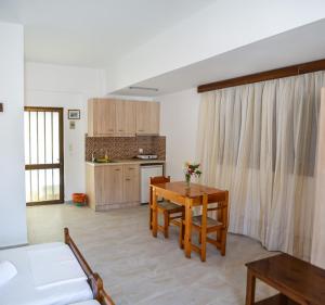 a living room with a table and a kitchen at Kalypso in Agia Galini