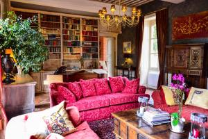 sala de estar con sofá rojo y mesa en Chateau d'Origny, Chambres d'hotes et Restaurant Gastronomique, en Ouches