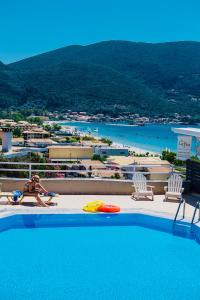 a woman is laying on the edge of a swimming pool at Ponti Beach Hotel in Vasiliki