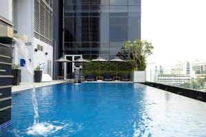 a swimming pool with a fountain in the middle of it at Novotel Bangkok Ploenchit Sukhumvit - SHA EXTRA PLUS in Bangkok