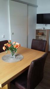 a vase of flowers sitting on a wooden table at Ferienwohnung Tahedl in Wegscheid