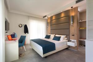 Astoria Suite Hotel في ريميني: غرفة نوم بسرير وكرسي ومكتب