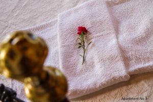 a rose on a white towel with a flower on it at Villa Bella Leros in Agia Marina