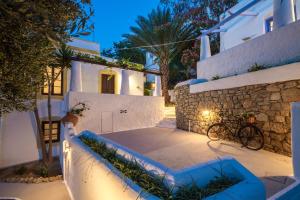 a house with white walls and a stone wall at Villa Bella Leros in Agia Marina