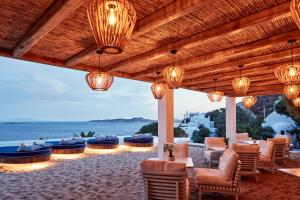 patio z krzesłami i stołami oraz widokiem na ocean w obiekcie Katikies Mykonos - The Leading Hotels of the World w mieście Agios Ioannis