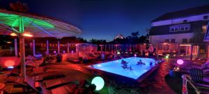 a group of people in a swimming pool at night at Vakantiehotel Der Brabander Apartments in Winterberg +44 photos