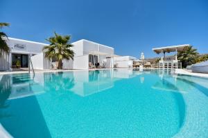 a large pool with blue water in front of a building at Queen Boutique Suites in Mýkonos City