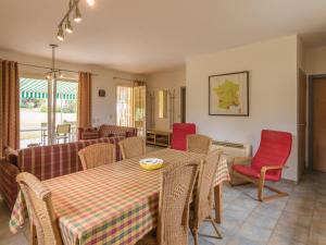 a dining room with a table and red chairs at Two comfortable houses with swimming pool near Monbazillac and Bergerac in Saint-Nexans