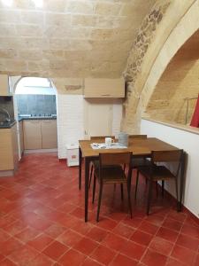 cocina con mesa y sillas en una habitación en Casa Vacanze IL SEDILE en Oria