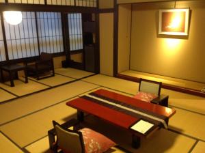 a room with a table and some chairs and a table and a tablektop at Kanazawa Chaya in Kanazawa