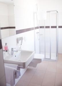 een witte badkamer met een wastafel en een toilet bij Gleiseins in Naila