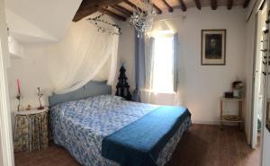 a bedroom with a bed with a blue bedspread and a window at La casina delle rondini in Corsanico-Bargecchia