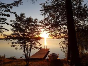 uma doca num lago com o pôr do sol em Niemilomat em Varkaus
