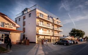 wysoki budynek z ludźmi stojącymi poza nim w obiekcie Al Mare - Apartamenty i pokoje w Sarbinowie