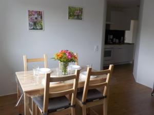 a dining room table with chairs and a vase of flowers at Gästezimmer Fechheim in Neustadt bei Coburg