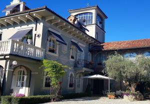 - un grand bâtiment avec un balcon en haut dans l'établissement La Ribezza Boutique Hotel - Adults Only, à Monforte dʼAlba