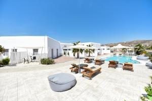 un patio con piscina y sillas y una piscina en Queen Boutique Suites, en Mykonos ciudad