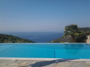 a blue swimming pool with a view of the ocean at Elies Houses in Agnontas