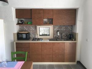 a small kitchen with wooden cabinets and a microwave at Lamia Bianca in Locorotondo