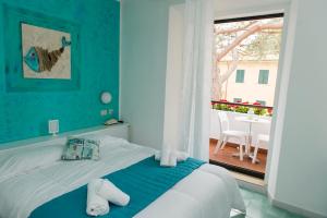 a bedroom with a bed with a blue wall at Hotel Punto Verde in Marina di Campo