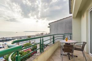 a balcony with a table and chairs and a view of the ocean at Pink in Tučepi