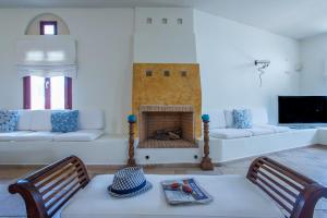 a living room with a fireplace with a table and chairs at Naxos Palace Hotel in Stelida