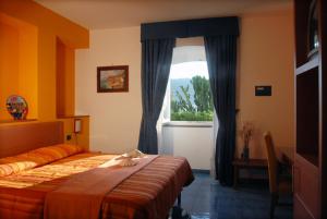 a bedroom with a bed and a window at Hotel La Tonnara in Procida