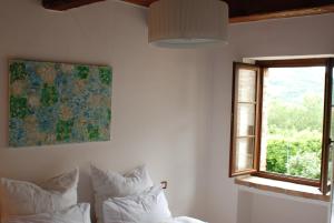 a bedroom with white walls and a window and pillows at Casa Vinto in Cagli