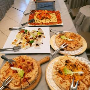 stół z kilkoma pizzami na talerzach w obiekcie Hotel Pacific w mieście Cattolica