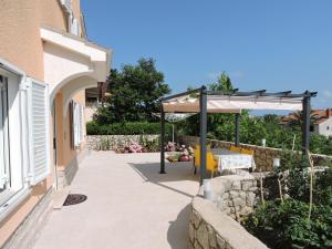 a patio of a house with a table at Neda Apartmani in Mali Lošinj