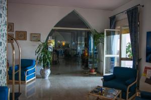a living room with blue chairs and a table at Park Hotel Silemi in Letojanni +186 photos