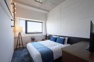 מיטה או מיטות בחדר ב-Kawasaki King Skyfront Tokyu REI Hotel