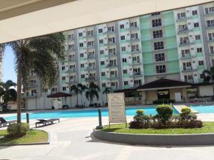 a large apartment building with a large swimming pool at Genesis unit SMDC Fields in Manila