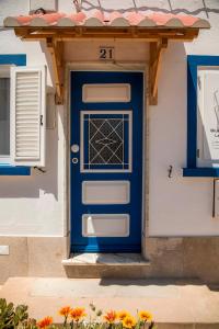 una porta blu sul lato di una casa con fiori di Blue Door Lagos a Lagos