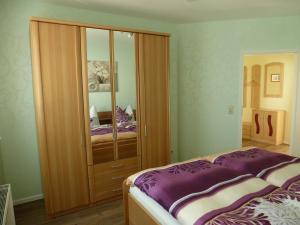 ツィノヴィッツにあるFerienwohnung Glienbergwegのベッドルーム1室(ベッド1台、大きな木製クローゼット付)