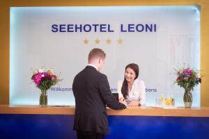 a man and a woman standing next to each other at Seehotel Leoni in Berg am Starnberger See