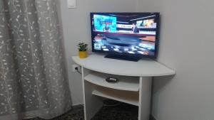 een televisie op een wit bureau in een kamer bij Crystal Home near Airport in Artemida